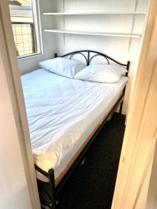 een slaapkamer met een bed in een kamer met een raam bij Chalet op 5 ster CampingPark Capfun de Bongerd in Tuitjenhorn
