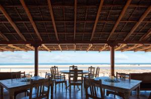a restaurant with tables and chairs on the beach at Vaayu Kula mandrem in Mandrem
