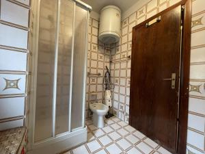 a bathroom with a toilet and a wooden door at Appartamento bilocale centralissimo 013 in Pinzolo