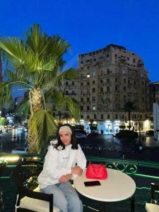 Eine Frau, die an einem Tisch mit einer roten Handtasche sitzt. in der Unterkunft Cairo Inn in Kairo