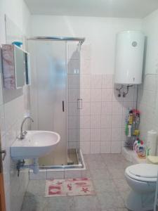 uma casa de banho com um chuveiro, um lavatório e um WC. em Ferienhaus in Balatonfkajár mit Grill, Garten und Terrasse em Balatonfőkajár