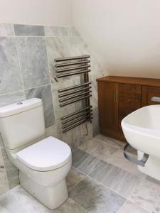 La salle de bains est pourvue de toilettes blanches et d'un lavabo. dans l'établissement Sanctuary Cottage - close to the centre of Anstruther, à Fife
