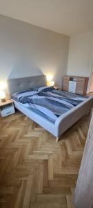 a large bed in a room with a wooden floor at Apartmán Petzvalova 51 in Myslava