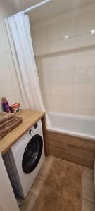 uma máquina de lavar roupa na casa de banho com banheira em Apartmán Petzvalova 51 em Myslava