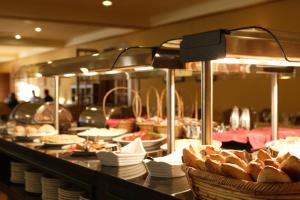 a buffet line with bread and plates on a table at Balneario de Mondariz in Mondariz-Balneario
