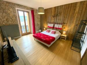 ein Schlafzimmer mit einem Bett und einem TV in der Unterkunft Le joli bois 12 personnes 5/ch spa/sauna Gérardmer in Gérardmer