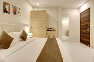 a bedroom with a large white bed and a bathroom at Limewood Stay - Corporate Huda City Centre in Gurgaon