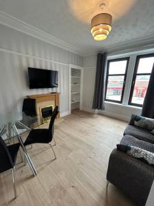 a living room with a couch and a fireplace at Class Apartments in Peterhead