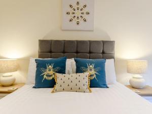 a bedroom with a white bed with blue pillows at 2 Bed in Brassington 77632 in Brassington