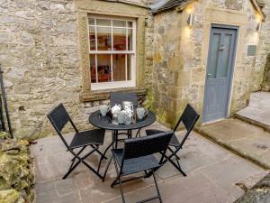 a patio with a table and chairs in front of a building at 2 Bed in Brassington 77632 in Brassington