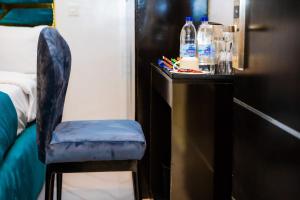 krzesło siedzące obok stołu z butelkami wody w obiekcie El Elyon Hotel and Suites w mieście Lagos