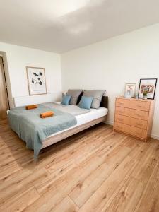a bedroom with a large bed and a wooden floor at Nadštandardný apartmán s terasou in Tisovec