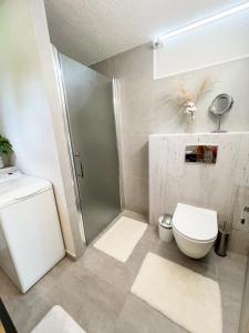 a white bathroom with a toilet and a shower at Nadštandardný apartmán s terasou in Tisovec +11 photos