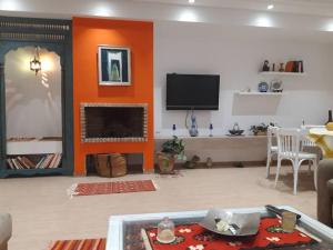 een woonkamer met een open haard en een televisie bij Dar Douja / Grandview Waterfront Duplex / Four seasons in Sfax