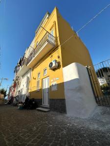 um edifício amarelo no lado de uma rua em La Casa dei Sogni em Procida
