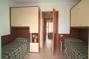 a bedroom with two beds and a door to a hallway at Ferienhaus für 10 Personen in Bibione, Adriaküste Italien in Bibione
