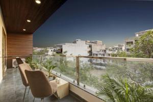 einen Balkon mit Stühlen und Stadtblick in der Unterkunft Limewood Stay - Corporate Huda City Centre in Gurgaon