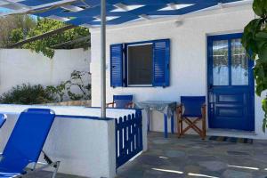 eine Terrasse mit blauen Stühlen und einem Tisch sowie einer blauen Tür in der Unterkunft Vromolithos view in Vromolithos