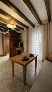 una sala de estar con una mesa con dos vasos. en “La Carpintería” en Prado del Rey