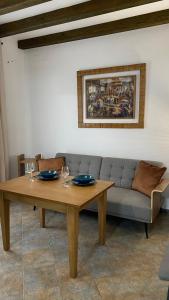 mesa y sofá en la sala de estar en “La Carpintería” en Prado del Rey