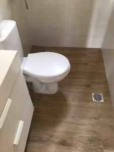 ein Badezimmer mit weißer Toilette und Holzboden in der Unterkunft Vromolithos view in Vromolithos + 7 Fotos