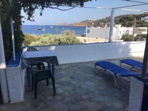 eine Terrasse mit Tisch und Stühlen und Blick aufs Wasser in der Unterkunft Vromolithos view in Vromolithos