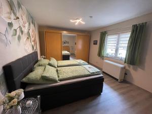 a bedroom with a bed with green pillows at Ferienwohnung Emma in Steinwiesen