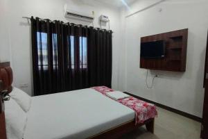 a small bedroom with a bed and a television at Champaran Home Deluxe in Varanasi