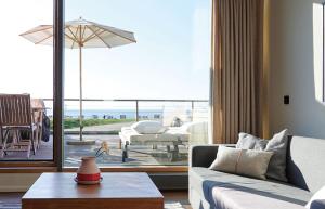 Hotel Haus am Meer في نورديرني: غرفة معيشة مع أريكة وإطلالة على المحيط