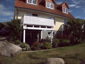 a house with a yard with rocks in front of it at Ferienhaus Sonne & Meer für 7 Personen mit Sauna und Whirpool in Kühlungsborn