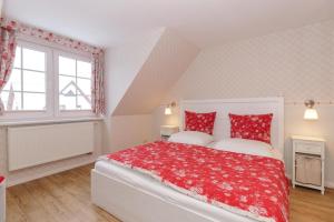 a bedroom with two red pillows on a bed at Ferienhaus Sonne & Meer für 7 Personen mit Sauna und Whirpool in Kühlungsborn