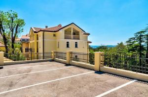ein großes gelbes Haus mit einem Zaun und einem Parkplatz in der Unterkunft Gästezimmer für 2 Personen ca 28 m in Crikvenica, Kvarner Bucht Crikvenica und Umgebung in Crikvenica