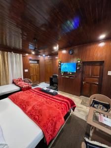 a bedroom with a bed and a flat screen tv at Gayatri Niwas - Luxury Private room with Ensuit Bathroom - Lake View and Mountain View in Nainital