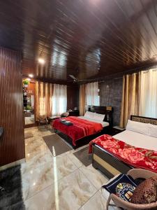 a bedroom with two beds and a red blanket at Gayatri Niwas - Luxury Private room with Ensuit Bathroom - Lake View and Mountain View in Nainital