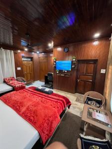 Schlafzimmer mit einem Bett und einem Flachbild-TV in der Unterkunft Gayatri Niwas - Luxury Private room with Ensuit Bathroom - Lake View and Mountain View in Nainital