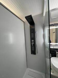 a bathroom with a shower with a phone on the wall at Unique Houseboat Modern and New in Fort Lauderdale +25 photos