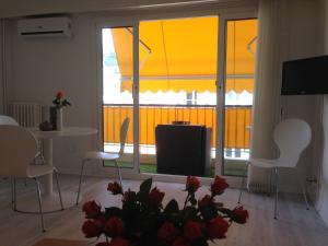 a living room with a table and chairs and a large window at Studio Residence Du Casino in Menton