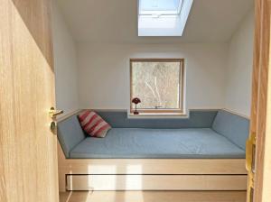 Bett in einem Zimmer mit Fenster in der Unterkunft Remise am Fährhaus in Ulsnis