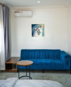 Sofá azul en la sala de estar con mesa en Duplex16 en Enugu