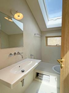 ein Bad mit einem Waschbecken und einem Spiegel in der Unterkunft Remise am Fährhaus in Ulsnis