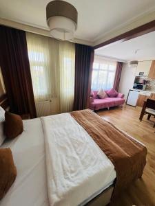 a bedroom with a large bed and a living room at Aycan Sultan Apart Hotel in Istanbul