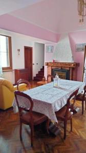 een eetkamer met een tafel en een open haard bij La casa di nonna Mary in Diano Castello