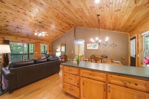ein Wohnzimmer mit einem Sofa und einem Tisch in der Unterkunft Peaceful Smoky Mountain Cabin with Deck and Fire Pit! in Waynesville