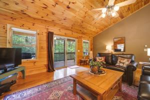 ein Wohnzimmer mit einem Sofa und einem Tisch in der Unterkunft Peaceful Smoky Mountain Cabin with Deck and Fire Pit! in Waynesville