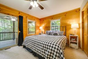 Schlafzimmer mit einem Bett und einem Deckenventilator in der Unterkunft Peaceful Smoky Mountain Cabin with Deck and Fire Pit! in Waynesville