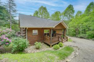 a cabin in the woods with a porch and a deck at Peaceful Smoky Mountain Cabin with Deck and Fire Pit! in Waynesville