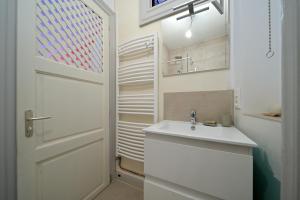 biała łazienka z umywalką i drzwiami w obiekcie Maison Familiale w mieście Luchon