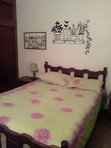 Un dormitorio con una cama con flores rosas. en Casa-Quinta c-lindo Amb Familiar en Valencia