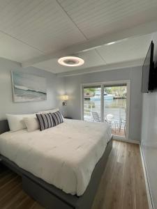 1 dormitorio con 1 cama grande y balcón en Unique Houseboat Modern and New, en Fort Lauderdale