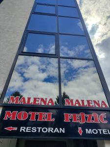 a reflection of the milan metro sign in a window at Malena in Goražde